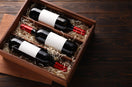 Box with wine bottles on wooden table